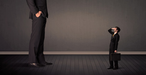 Fototapeta premium Mały biznesmen przed koncepcją gigantycznych nóg szefa