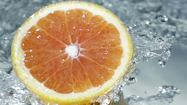 Halved grapefruit in running water