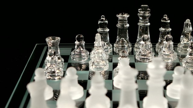 4K. Hand making a winning chess move  isolated on black