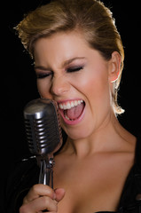 Woman singing loudly into microphone