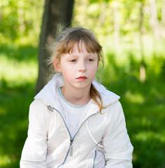 portrait of a beautiful girl in a park on the autistic grass