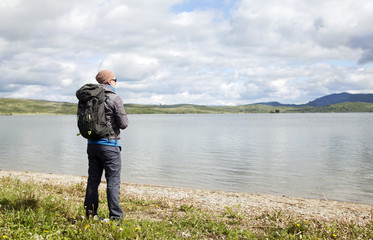 Fototapeta na wymiar the traveler with a backpack at the lake