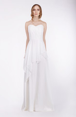 Fototapeta na wymiar Fashion Model Standing in Long White Dress