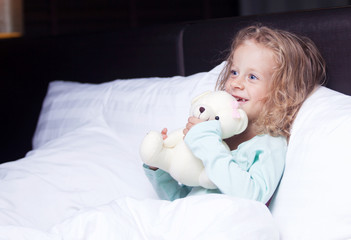 the little girl in bed with a toy