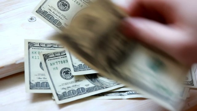 Businessman believes the money around a wooden table