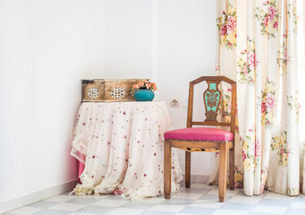 Vintage style interior with table, chair and floral curtain