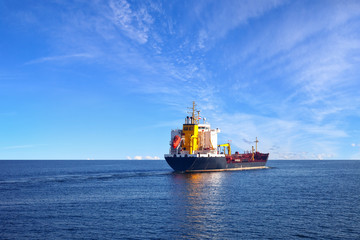 Oil tanker ship at sea on a background of blue sky.