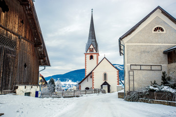 Fototapeta na wymiar old catholic church in small Austrian town covered by snow