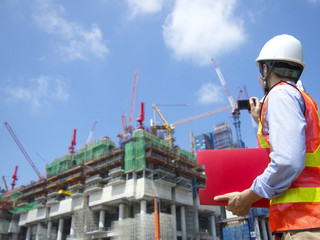 Consrtuction worker taking photos with a red file
