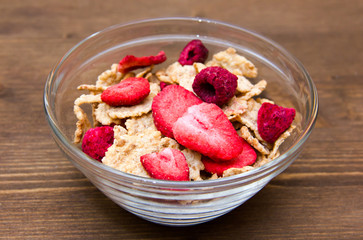 Bowl with cereals and fruits on wooden table