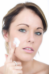Obraz na płótnie Canvas Attractive Young Woman Applying Moisturizing Cream