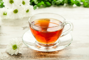 Glass cup of tea on a wooden table.