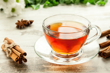 Glass cup of tea on a wooden table.