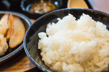 White steamed rice in black round bowl