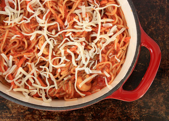 Spaghetti with grated cheese, in red dutch oven