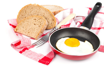Fried egg in a frying pan, over white background