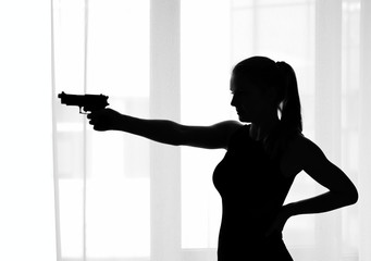 Silhouette of the girl with a gun