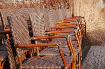 Fototapeta na wymiar Wicker chairs on the terrace in the garden cafe.