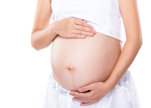 Pregnant woman touching her belly with hand