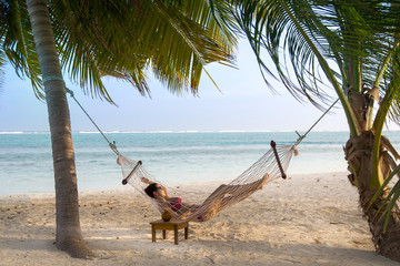 Frau entspannt in Hängematte auf exotischer Insel