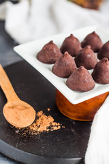 chocolate truffles, cocoa powder in a wooden spoon
