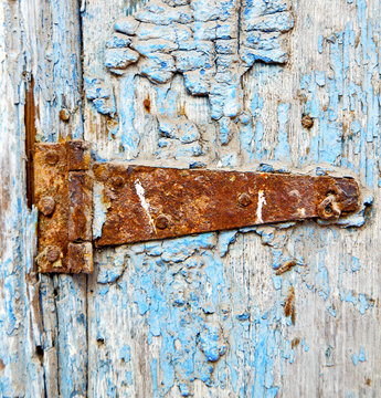 rusty metal     nail dirty stripped paint in the blue wood door