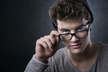 Cool young man adjusting his glasses