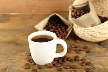 Cup of coffee with beans on rustic wooden background