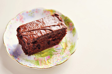 Dark chocolate cake on porcelain saucer