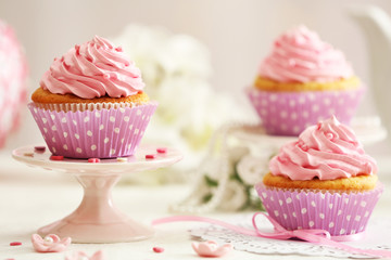 Delicious cupcakes on table on light background