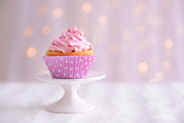 Sweet cupcake on table on light background