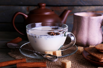 Black tea with milk in cups and teapot with lump sugar