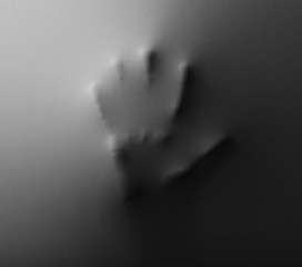 Hand pressing through fabric as horror background