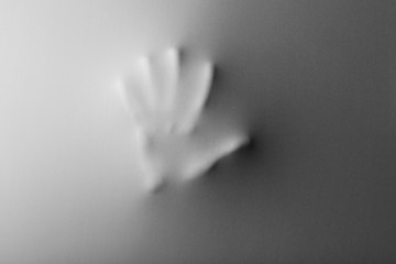 Hand pressing through fabric as horror background