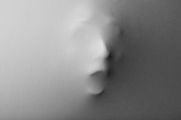 Screaming human face pressing through fabric as horror