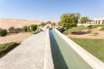 Naklejka premium Irrigation canal in a desert resort. Emirate of Abu Dhabi