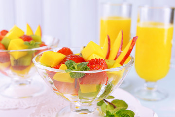 Fruit salad with mint and orange juice in glassware