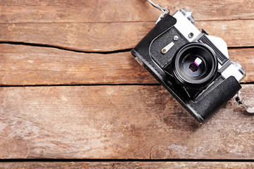 Old retro camera on rustic wooden planks background