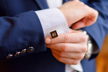 a man fastens a cuff-link