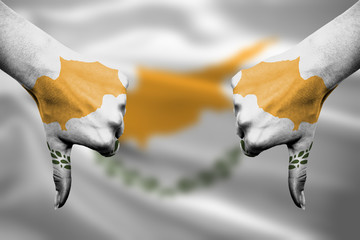failure of Cyprus - hands gesturing thumbs down in front of flag