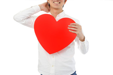 真っ赤なハートを持って悩んでいる男性