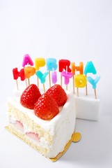 HappyBirthdayの文字のロウソクとイチゴのケーキ