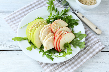 Light salad with apples, celery and arugula on a plate