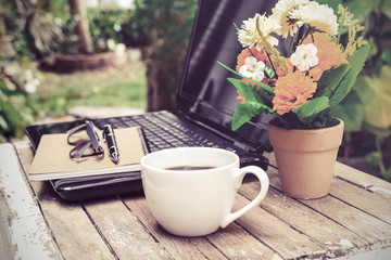 cup of coffee and laptop on wooden table