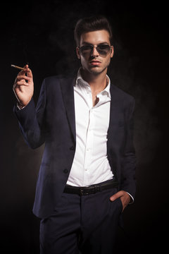 young handsome business man enjoying a cigarette