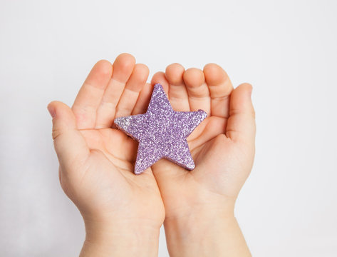 Hands Of A Child Holding Small Star