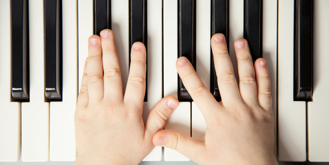 Child's hands playing the piano
