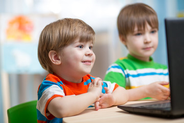 happy kids looking at laptop