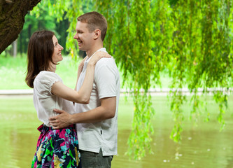 Fototapeta premium Cute young couple under green willow