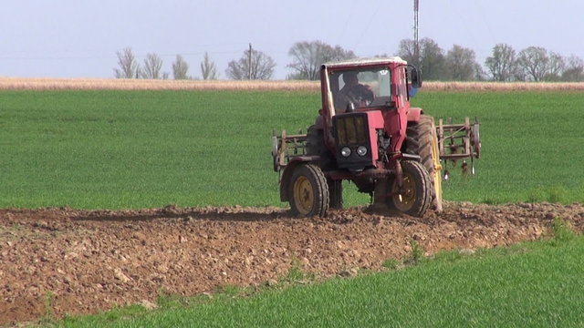 small old agriculture tractor cultivated field soil in spring